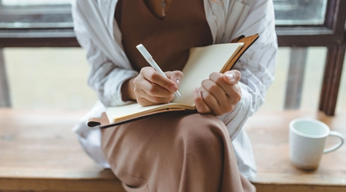 Woman writing notes in a planner